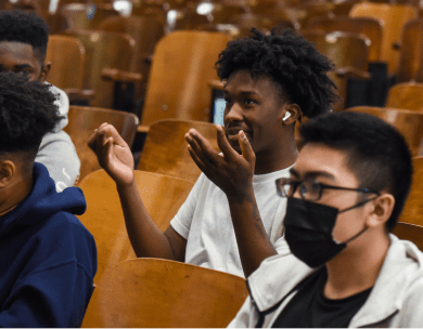 Seated high school audience members participating in a discussion while attending a presentation